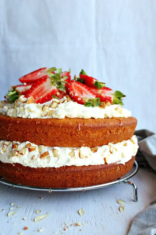 Zesty Orange Honey Layer Cake. The moistest, most tasty orange sponge cake with whipped cream & chopped almond layers & fresh strawberries on top. AMAZING! | berrysweetlife.com