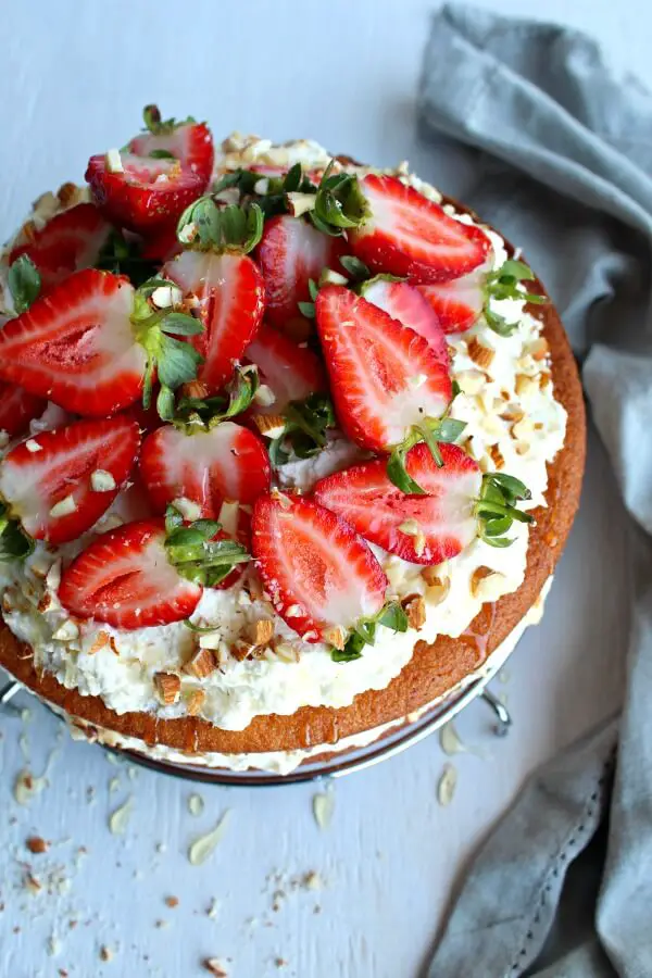 Zesty Orange Honey Layer Cake. The moistest, most tasty orange sponge cake with whipped cream & chopped almond layers & fresh strawberries on top. AMAZING! | berrysweetlife.com