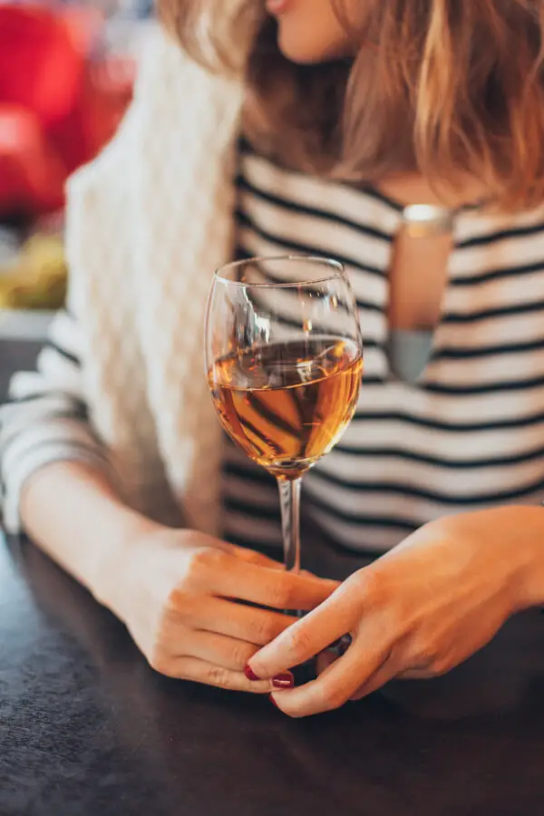 Woman holding white wine