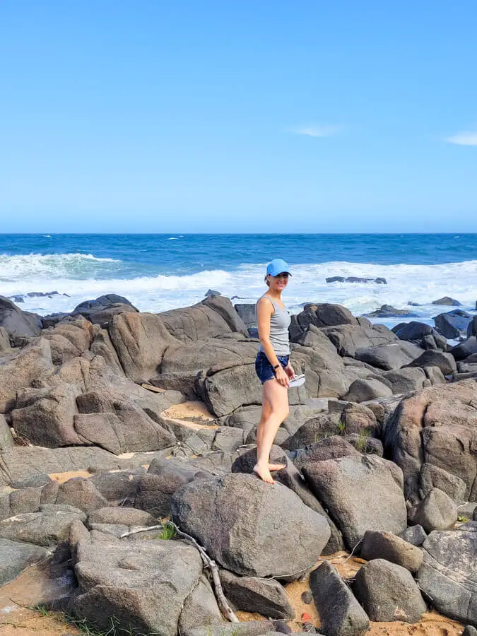 Woman on rocks with ocean behind